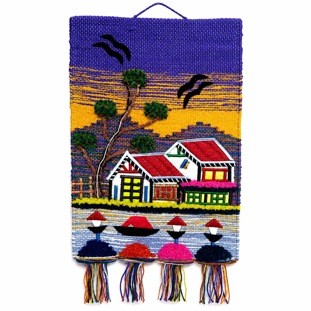 Violet and yellow handwoven wall hanging with a two-storey cottage, boat and four tasselled pompoms