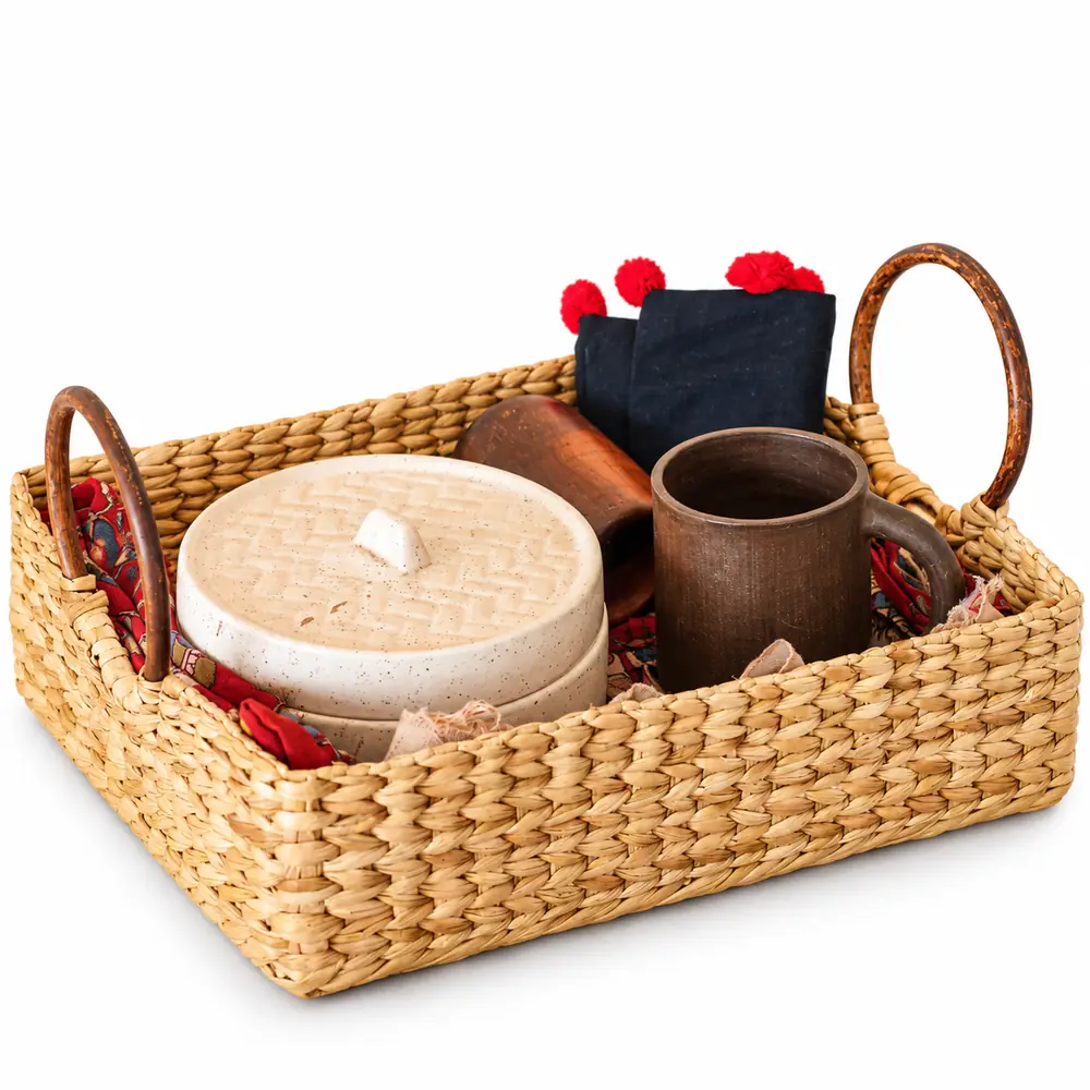 Natural water reed woven table basket holding a ceramic dish, mug and napkins